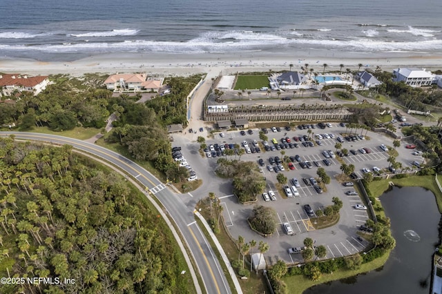 birds eye view of property featuring a water view and a beach view