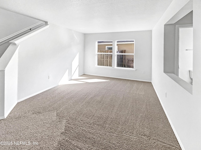 bonus room featuring baseboards, a textured ceiling, and carpet flooring