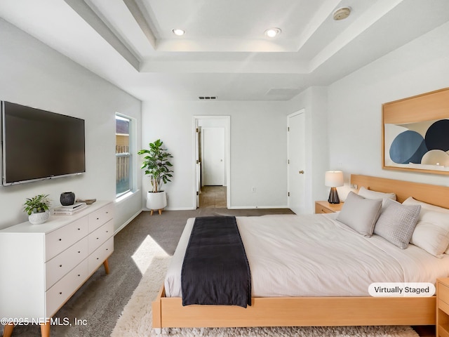 bedroom with dark colored carpet, a raised ceiling, baseboards, and recessed lighting