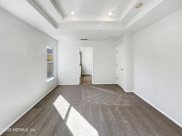 unfurnished bedroom with baseboards, a raised ceiling, carpet flooring, and recessed lighting