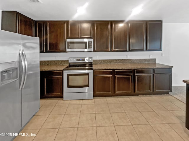 kitchen with appliances with stainless steel finishes, dark countertops, and dark brown cabinetry