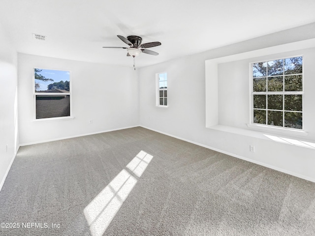 spare room featuring visible vents, carpet flooring, a ceiling fan, and baseboards