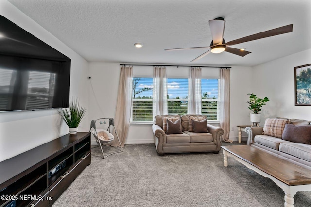 carpeted living area with ceiling fan, baseboards, and a textured ceiling