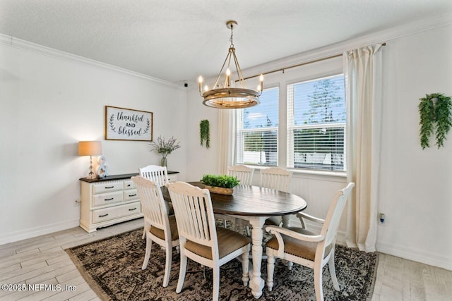 dining space featuring baseboards, a textured ceiling, crown molding, light wood-style floors, and a notable chandelier