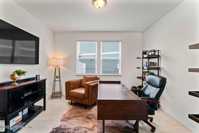 office space featuring baseboards and wood finished floors