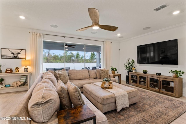 living area featuring ornamental molding, wood finished floors, visible vents, and recessed lighting