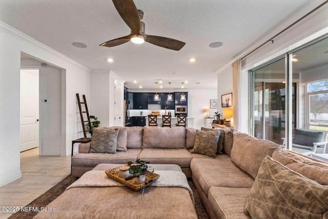 living room with a textured ceiling, recessed lighting, light wood-style flooring, and crown molding