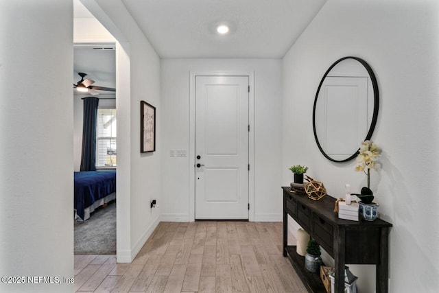 foyer entrance with light wood-type flooring and baseboards