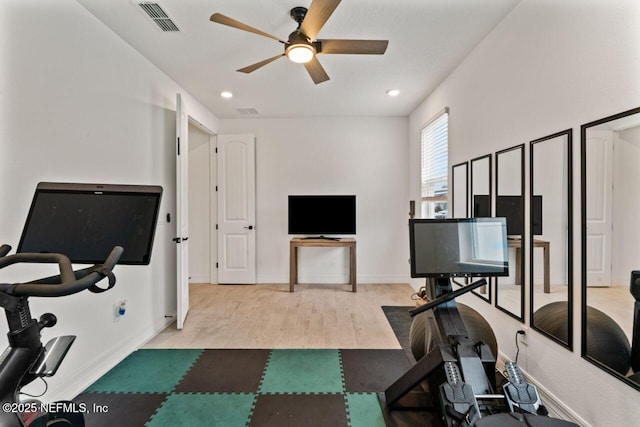 workout room featuring visible vents, ceiling fan, baseboards, and wood finished floors