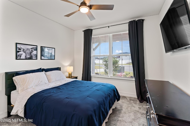 bedroom featuring ceiling fan, baseboards, and light colored carpet