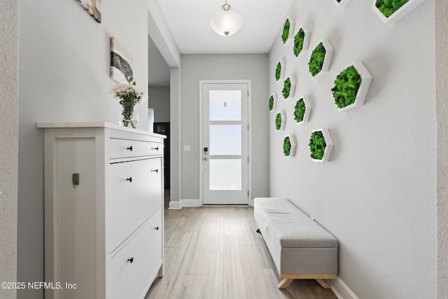 doorway with light wood-style floors and baseboards