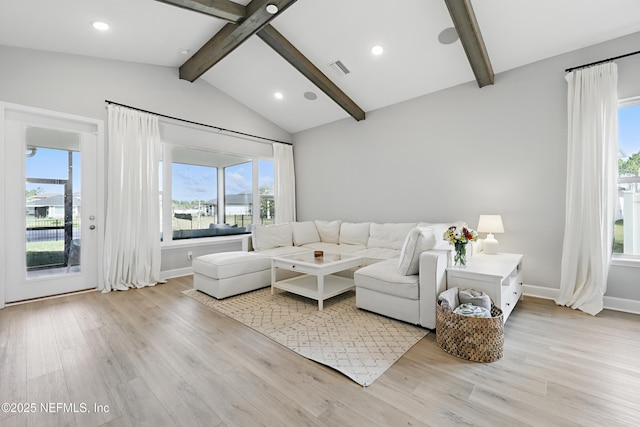 living room with vaulted ceiling with beams, light wood finished floors, visible vents, and baseboards