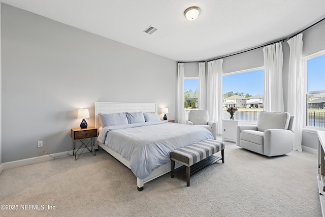 bedroom featuring visible vents, light carpet, and baseboards