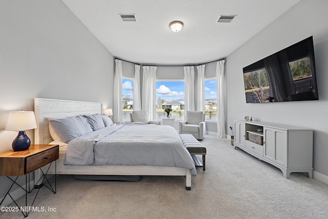 bedroom with light colored carpet, visible vents, and baseboards