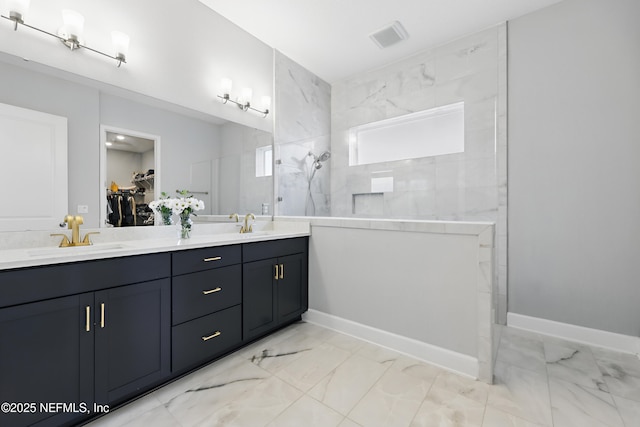 full bath featuring a walk in shower, a sink, a spacious closet, marble finish floor, and double vanity