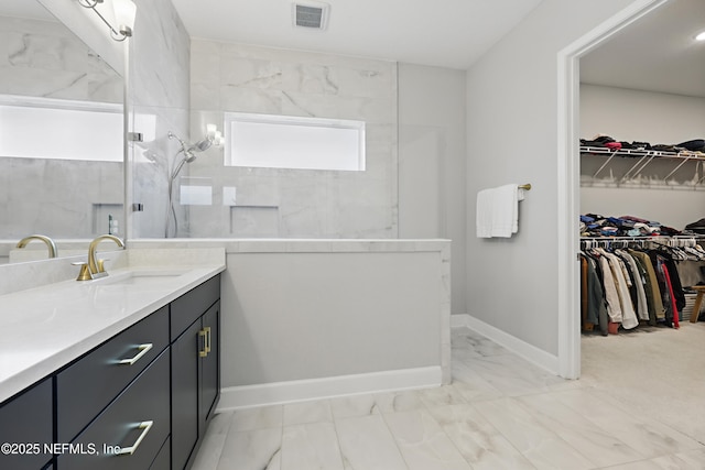 full bath featuring marble finish floor, visible vents, vanity, a walk in shower, and baseboards