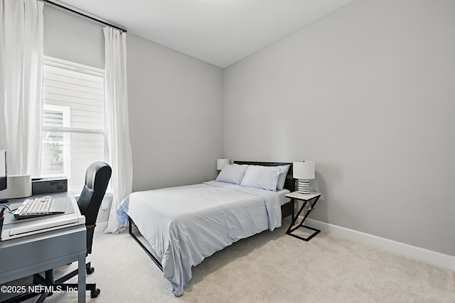 bedroom featuring light carpet and baseboards