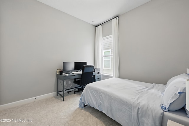 bedroom featuring light colored carpet and baseboards