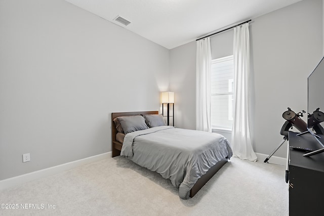 bedroom featuring baseboards, visible vents, and light colored carpet