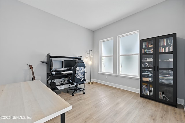 office space with light wood-type flooring and baseboards