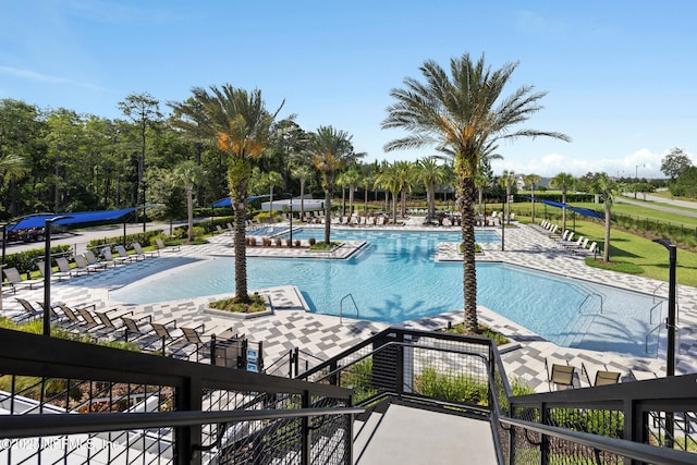 community pool with a patio area and fence