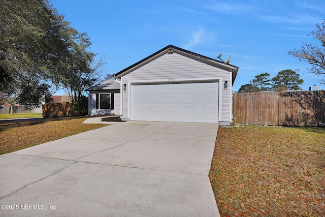 view of front of property with a garage, concrete driveway, fence, and a front lawn