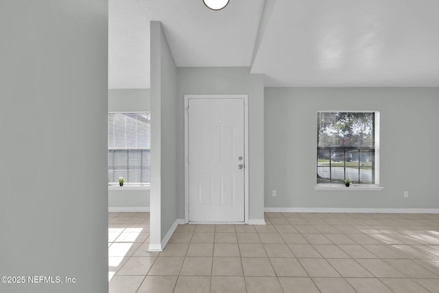 foyer featuring light tile patterned floors and baseboards