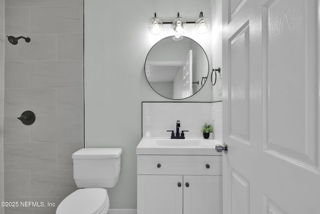 full bathroom with toilet, backsplash, and vanity