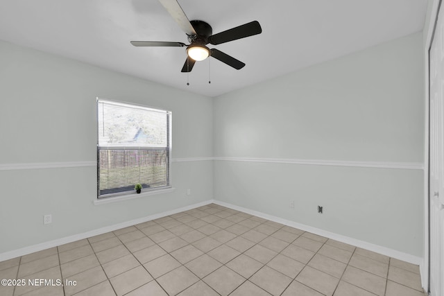 unfurnished room with ceiling fan and baseboards