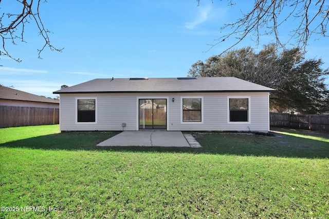 rear view of property with a patio, a lawn, and a fenced backyard