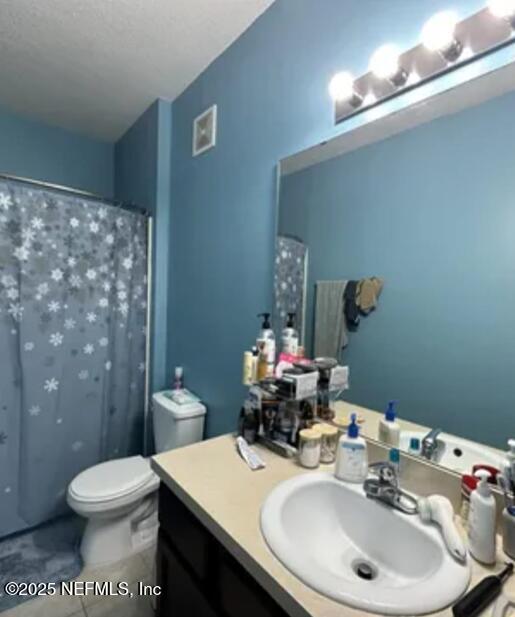 full bathroom featuring toilet, curtained shower, tile patterned floors, and vanity