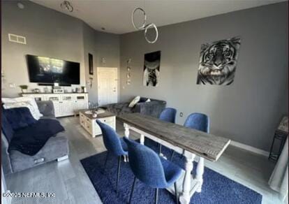 dining space featuring visible vents, baseboards, and wood finished floors