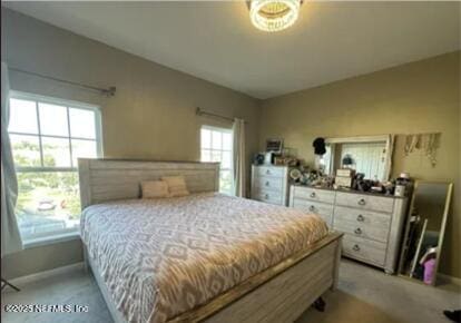 bedroom featuring baseboards and light colored carpet