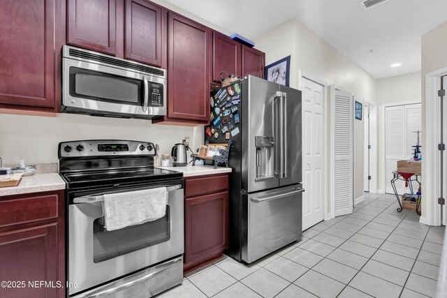 4920 Key Lime Dr Unit 305, Jacksonville, FL 32256 - kitchen featuring stainless steel appliances, reddish brown cabinets, light tile patterned flooring, and light countertops