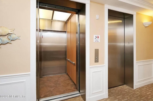 details with elevator, wainscoting, and a decorative wall