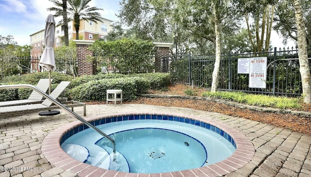 view of swimming pool featuring fence and a hot tub