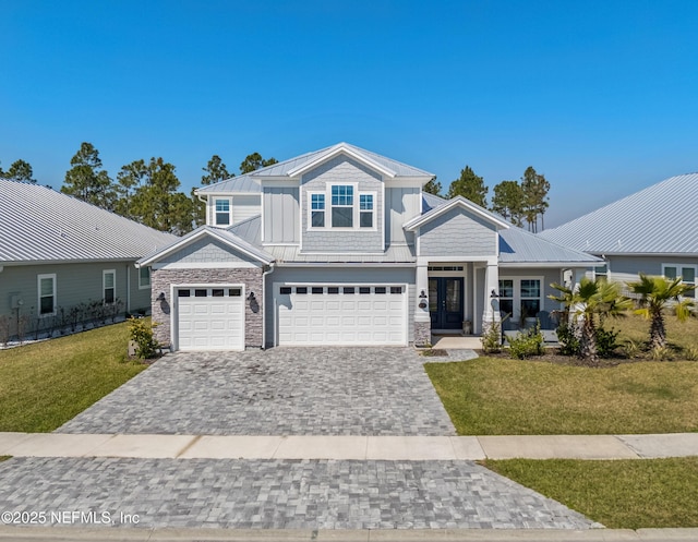 view of front facade featuring a standing seam roof, metal roof, a front lawn, and decorative driveway