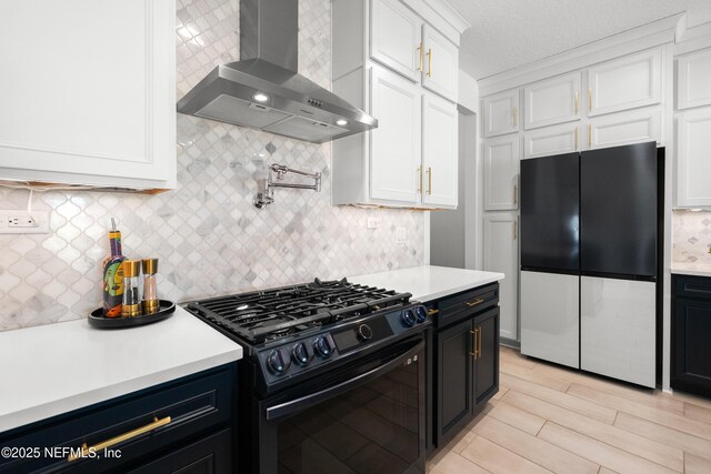 230 Marquesa Cir, Saint Johns, FL 32259 - kitchen featuring light countertops, wall chimney range hood, black range with gas stovetop, and freestanding refrigerator