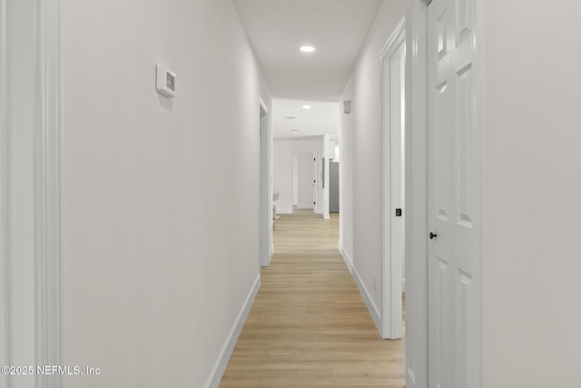 corridor with recessed lighting, light wood-style flooring, and baseboards