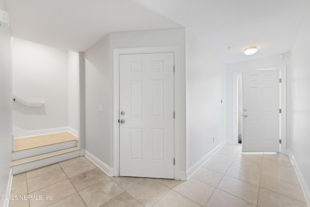 hallway featuring light tile patterned flooring and baseboards