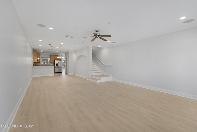 unfurnished living room featuring light wood-style flooring, recessed lighting, ornamental molding, and stairway