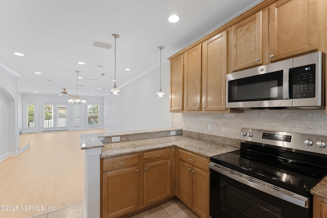 kitchen with a peninsula, appliances with stainless steel finishes, light stone countertops, tasteful backsplash, and decorative light fixtures