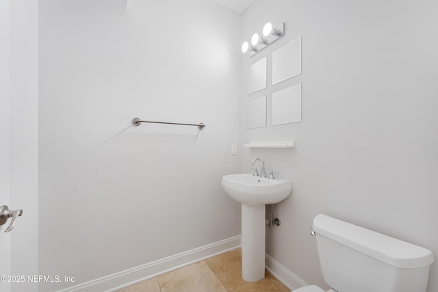 bathroom featuring tile patterned flooring, toilet, and baseboards