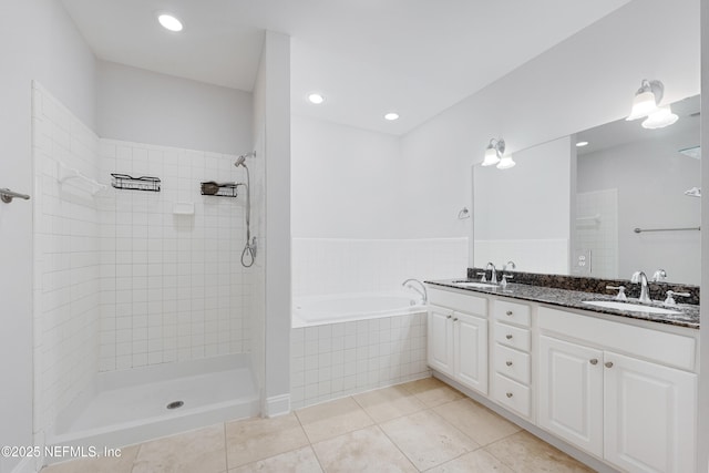 bathroom with a tile shower, tile patterned flooring, a sink, and a garden tub