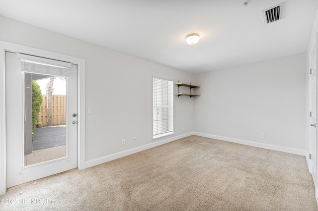 spare room with light carpet, baseboards, and visible vents