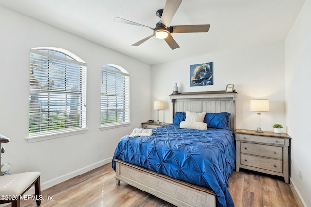 bedroom with wood finished floors, a ceiling fan, and baseboards