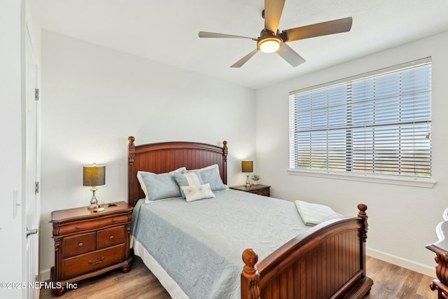 bedroom with ceiling fan, baseboards, and wood finished floors