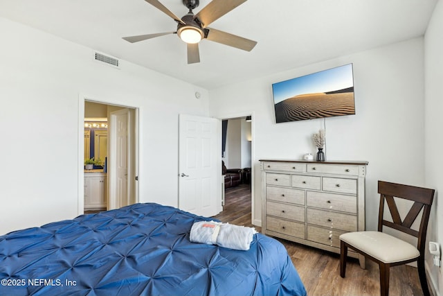 bedroom featuring visible vents, ceiling fan, ensuite bathroom, and wood finished floors