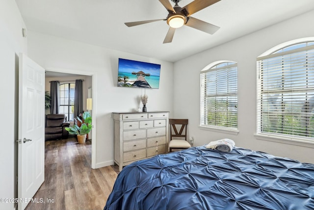 bedroom with wood finished floors, a ceiling fan, and baseboards