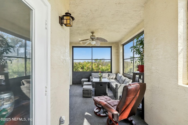 sunroom / solarium featuring a ceiling fan